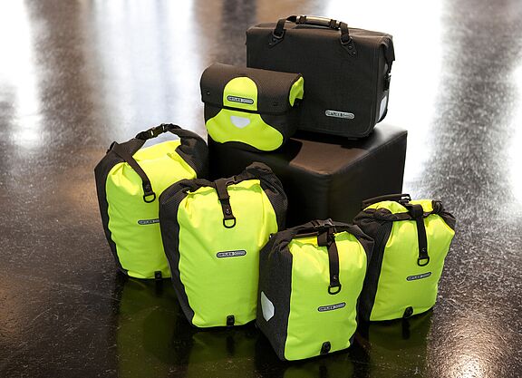 Komplett reflektierende Taschenset mit Back- und Frontrollern und Lenkertasche in gelb, Fahrradaktentasche in schwarz. Komplett reflektierende Taschenset mit Back- und Frontrollern und Lenkertasche in gelb, Fahrradaktentasche in schwarz.
